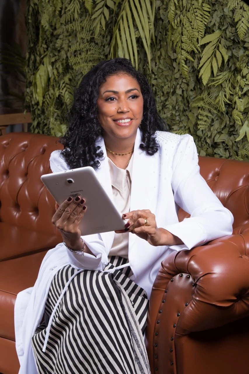 Dra. Aline Cadamuro sentada com um tablet